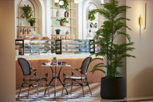 a restaurant with a table and chairs and a potted plant at Enorme Epavli Urban Living in Hersonissos