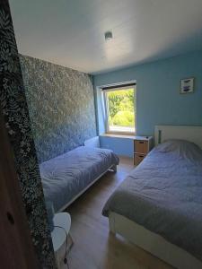 a bedroom with two beds and a window at Les Reflets de Meuse in Revin