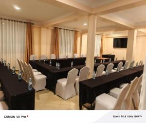 a conference room with black tables and white chairs at Spark Africa Hotel in Jinja