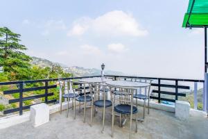 a table and chairs on a balcony with a view at Sagar plaza in Mussoorie