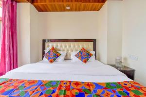 a bedroom with a large bed with a colorful comforter at Sagar plaza in Mussoorie