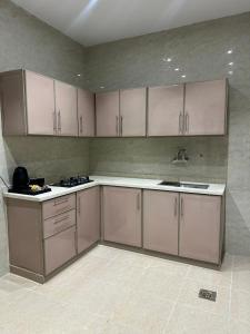 a kitchen with white cabinets and white counter tops at الملاذ الهادي in Al-ʿUla +30 photos