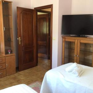 a room with a bed with a flat screen tv at HYP - Aranza Descanso Natural in Sotomayor