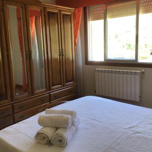 a bedroom with a bed with towels on it at HYP - Aranza Descanso Natural in Sotomayor