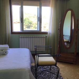 a bedroom with a bed and a mirror and a chair at HYP - Aranza Descanso Natural in Sotomayor +23 photos
