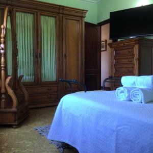 a bedroom with a bed with blue sheets and a flat screen tv at HYP - Aranza Descanso Natural in Sotomayor