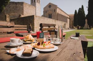 a wooden table with plates of food and cups of coffee at Domus Mirea in Aquiléia