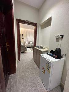 a room with a refrigerator and a kitchen with a couch at الملاذ الهادي in Al-ʿUla