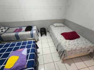 a bedroom with two beds and a tiled floor at Recanto do trabalho in Brasília