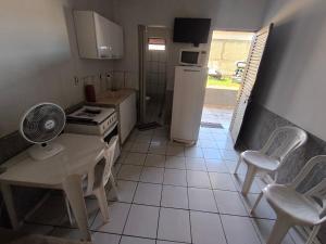 a kitchen with a table and chairs and a refrigerator at Recanto do trabalho in Brasília