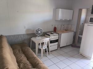 a kitchen with a couch and a table with a fan at Recanto do trabalho in Brasília
