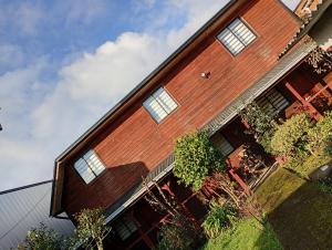 a house with windows on the side of it at Hostal y Cabañas Guaje in Valdivia