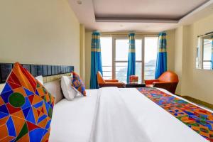 a bedroom with a large bed with blue curtains at Sagar plaza in Mussoorie