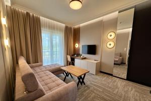 ein Wohnzimmer mit Sofa und Tisch in der Unterkunft Hotel Arkas in Proskau