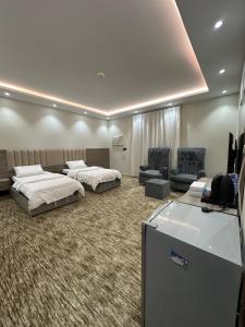 a hotel room with two beds and a couch at الملاذ الهادي in Al-ʿUla