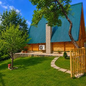 a large wooden house with a green roof at Etno house Bajka in Žabljak