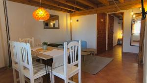 a dining room with a table and white chairs at Donde Elvira in Valderromán
