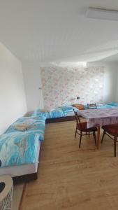 a bedroom with two beds and a table in it at La Flower Nesvady in Nesvady +8 photos