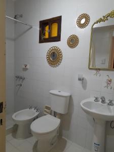 a white bathroom with a toilet and a sink at Temporario La Marcela in Resistencia