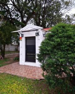 a small white dog house with a black door at Temporario La Marcela in Resistencia