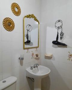 a white bathroom with a sink and a mirror at Temporario La Marcela in Resistencia