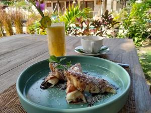 a plate of food on a table with a drink at Meno Dream Resort in Gili Meno