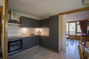 a kitchen with gray cabinets and a stove top oven at Val Pierre in Châtel