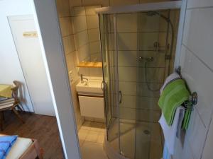 y baño con ducha y toalla verde. en Gästehaus Posch, en Krimml