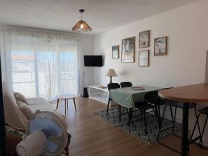a living room with a table and a dining room at Le cocon de Marennes in Marennes