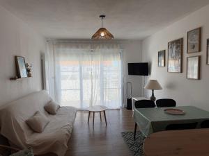 a living room with a couch and a table at Le cocon de Marennes in Marennes +3 photos