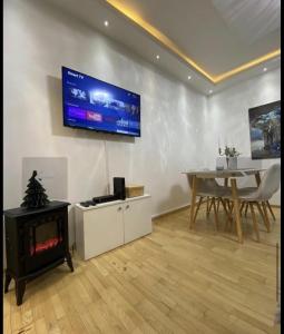 a living room with a fireplace and a tv on the wall at Apartman Ika in Belgrade