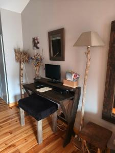 a desk with a computer and a lamp in a room at Hôtel Restaurant L'Arbre à Pain in Altier