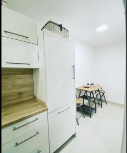a white refrigerator in a kitchen with a table at Apartman Ika in Belgrade +3 photos