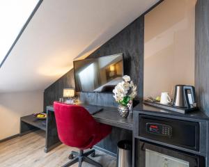 a room with a desk and a red chair at PLAZA INN Bruchsal in Bruchsal +57 photos