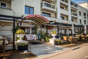 a restaurant with awning and tables and chairs in front of a building at Apartment Caricia complex Carpe Diem Balchik - sea view & free parking in Balchik