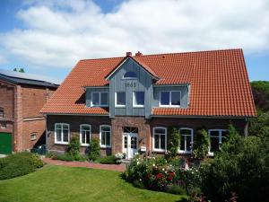ein Backsteinhaus mit orangefarbenem Dach in der Unterkunft Backhaus Meeresblick in Meeschendorf
