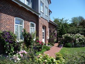 une maison en briques avec un jardin fleuri devant elle dans l'établissement Backhaus Meeresblick, à Meeschendorf