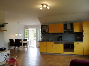 Meeschendorf的住宿－Backhaus Meeresblick，厨房配有黄色橱柜和桌椅