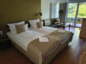 a bedroom with a large bed and a living room at Meerhotel Großenbrode in Großenbrode