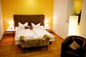 a bedroom with a large bed and a chair at Boutique-garni Hotel Papillon in Kempen