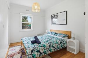 a bedroom with a bed and two windows at Coastal Cottage Retreat in Barwon Heads