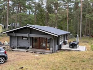 a small cabin with a deck in a yard at Yngsjö in Yngsjö