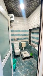a green and white bathroom with a toilet and a sink at Hotel Kaka Inn in Ajmer +43 photos