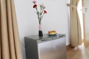 a vase with a flower on top of a small refrigerator at Enjoy Villa Da Lat in Khu Chi Lăng