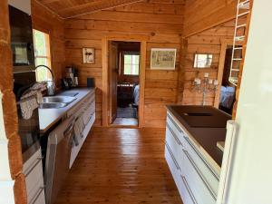 a kitchen with wooden walls and a wooden floor at Yngsjö in Yngsjö +8 photos