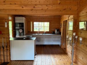 a kitchen in a log cabin with a sink at Yngsjö in Yngsjö