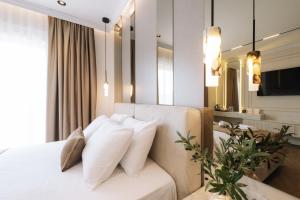 ein Schlafzimmer mit einem weißen Bett und weißen Kissen in der Unterkunft Hotel Dolcinium in Ulcinj