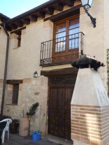 Casa con puerta de madera y balcón en La Fragua de los Alvaro, en Turégano