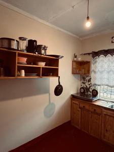 a kitchen with wooden cabinets and a pot hanging from the wall at Makao Home in Arusha