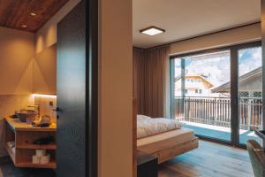 a bedroom with a bed and a balcony at Malojerhof in Lana
